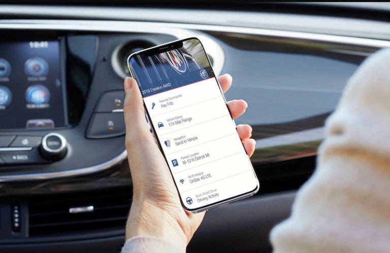 person holding phone with Buick Connected Services app in car